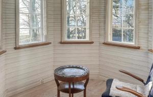 a room with a chair and a stool and windows at Villa Sommarro in Ystad