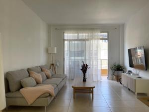 a living room with a couch and a tv at MarketHome Puertito de Guimar in Puertito de Güímar