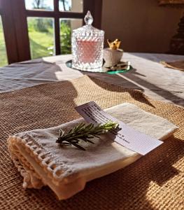 a table with a napkin with a candle and greens on it at La Perdida Casa de Campo in San Antonio de Areco