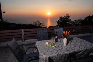 a table with a bottle of wine and a plate of food at Athanion Sunset House in Athani