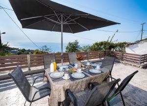 a table and chairs with an umbrella on a patio at Athanion Sunset House in Athani