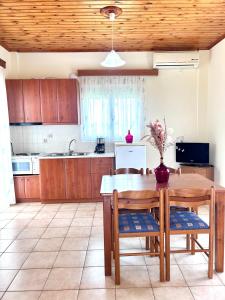 a kitchen with a wooden table and wooden cabinets at Orfanos Houses No2 in Koroni