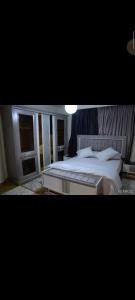 um quarto com uma grande cama branca em اكتوبر غرب سوميد em Cidade 6 de Outubro
