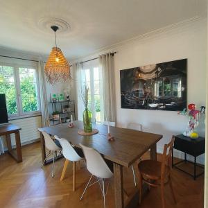 Maison de charme au cœur de Genève ! في جنيف: غرفة طعام مع طاولة وكراسي خشبية