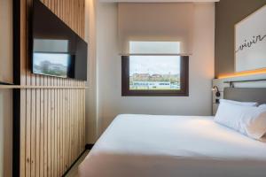 a bedroom with a large bed and a window at Leonardo Hotel San Sebastián in Donostia-San Sebastián