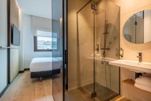 a bathroom with a shower and a sink at Leonardo Hotel San Sebastián in Donostia-San Sebastián