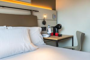 a bedroom with a bed with a desk and a bed sidx sidx sidx at Leonardo Hotel San Sebastián in Donostia-San Sebastián