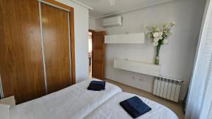 a bedroom with two beds and a vase of flowers at First Floor Apartment on La Torre Golf Resort- BO1212LT in Torre-Pacheco +35 photos