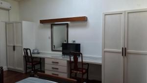 a room with a desk with a television and a mirror at Rainbow Inn in Grand Bras