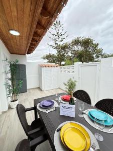 a dining room with a table with yellow plates on it at Calma & Mar in Arona