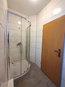 uma casa de banho com um chuveiro e uma porta de vidro em R&B Hotel em Berlim
