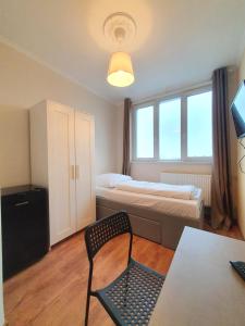 a bedroom with a bed and a chair and a table at R&B Hotel in Berlin