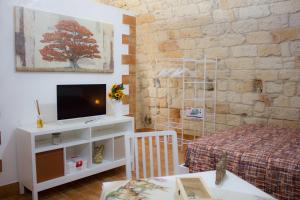 a living room with a tv and a bed at La Grottina in Bisceglie