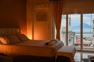 sypialnia z łóżkiem i dużym oknem w obiekcie Bill Apartments w mieście Patras