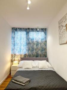 Coser Apartamenty Centrum في وارسو: غرفة نوم بسرير وستارة زرقاء