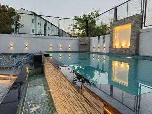 a swimming pool with lights on the side of a building at Kohinoor Exotica in Lonavala