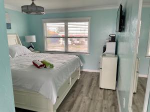 1 dormitorio con cama blanca y ventana en Flamingo Inn en Fort Myers Beach