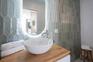 a bathroom with a large white bowl sink on a wooden counter at FLORIT FLATS - Stylish Studio by the Joaquin Sorolla Station in Valencia