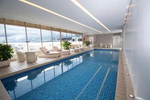 a large swimming pool with lounge chairs and a building at DoubleTree by Hilton Bogota Parque 93 in Bogotá