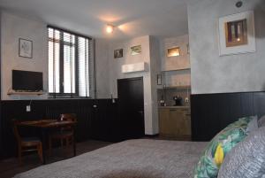1 dormitorio con cama, mesa y cocina en Swalmerkwartier en Roermond