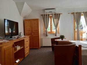 a bedroom with a bed and a television and a table at Hotel Koliba in Senec