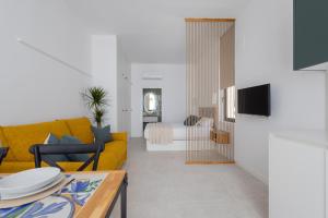 a living room with a yellow couch and a table at FLORIT FLATS - Stylish Studio by the Joaquin Sorolla Station in Valencia
