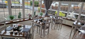 un restaurante con mesas, sillas y ventanas en Craigbank Guest House, en Crianlarich
