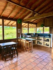 una cocina con mesas y sillas en una casa en Refugio Aventura, espectacular cabaña en las montañas de Tabio, Cundinamarca, en Tabio