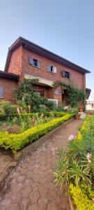 a brick house with a garden in front of it at Village NDJIKESSI in Yaoundé