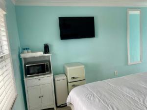 ein Schlafzimmer mit einem Bett und einer Mikrowelle an der Wand in der Unterkunft Flamingo Inn in Fort Myers Beach