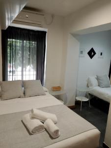 1 dormitorio con 2 camas y toallas. en PENSION CIBELES, en Córdoba
