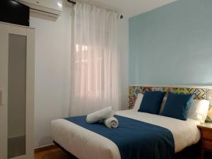 1 dormitorio con 2 camas y almohadas azules en PENSION CIBELES, en Córdoba