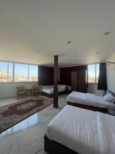 a hotel room with two beds and a large window at NEW ASSER HOTEL PYRAMID in Cairo