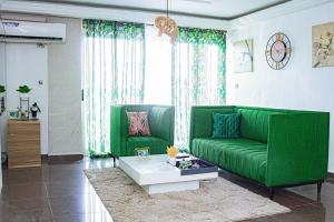 uma sala de estar com um sofá verde e uma mesa em appartement cosy moon bonapriso em Douala