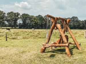 drewniana huśtawka na środku pola w obiekcie Camping Dal van de Mosbeek w mieście Mander
