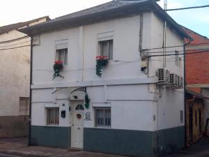 un edificio blanco con dos ventanas y flores. en Casa Mencía, en Camponaraya