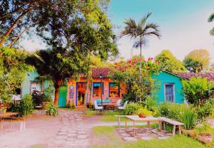 uma casa colorida com mesas e cadeiras no quintal em Refugio Trancoso suite Mare em Trancoso