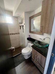 ein Badezimmer mit einem WC, einem Waschbecken und einem Spiegel in der Unterkunft Acogedor Apto en Bello, cerca del Metro in Bello