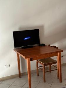 Piccolo appartamento a Prato في براتو: طاولة خشبية فوقها تلفزيون