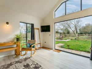 a living room with a large window and a tv at Bluebell Annexe in Sandy