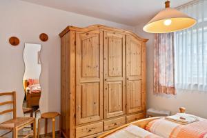 a bedroom with a wooden cabinet and a bed at Ferienwohnung Matt in Todtmoos