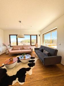 uma sala de estar com dois sofás e um tapete de vaca em Schwarzwald-Chalet Feldberg em Feldberg