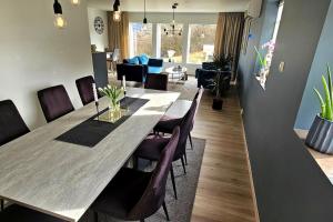 a dining room with a large table and chairs at Familie bolig med hage in Lyngdal