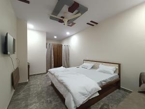 a bedroom with a large bed and a tv at RK RESIDENCY in Kothakota