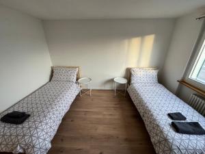 2 łóżka w małym pokoju z 2 krzesłami w obiekcie 4-Zimmerwohnung in Einfamilienhaus mit Garten und Parkplatz w mieście Volketswil