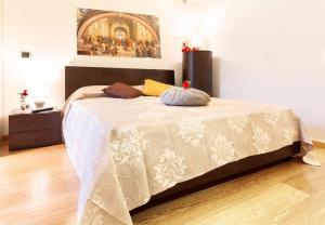 a bedroom with a large white bed with a painting on the wall at Gioia Romana in Rome