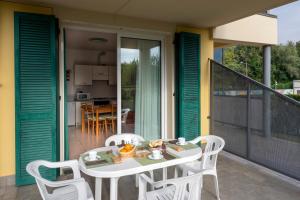 uma mesa branca e cadeiras numa varanda em Camping Residence & Lodge Orchidea em Baveno