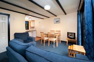 a living room with a blue couch and a table at Tolroy Manor Holiday Park in Hayle