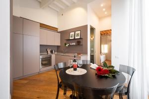 cocina y comedor con mesa negra y sillas en TG - One bedroom luxury apartment in the fashion district, en Florencia