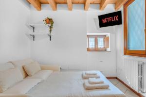 a white living room with a white couch and a sign at La Perla del Lago di Garda - Desenzano Couple's Loft in Desenzano del Garda